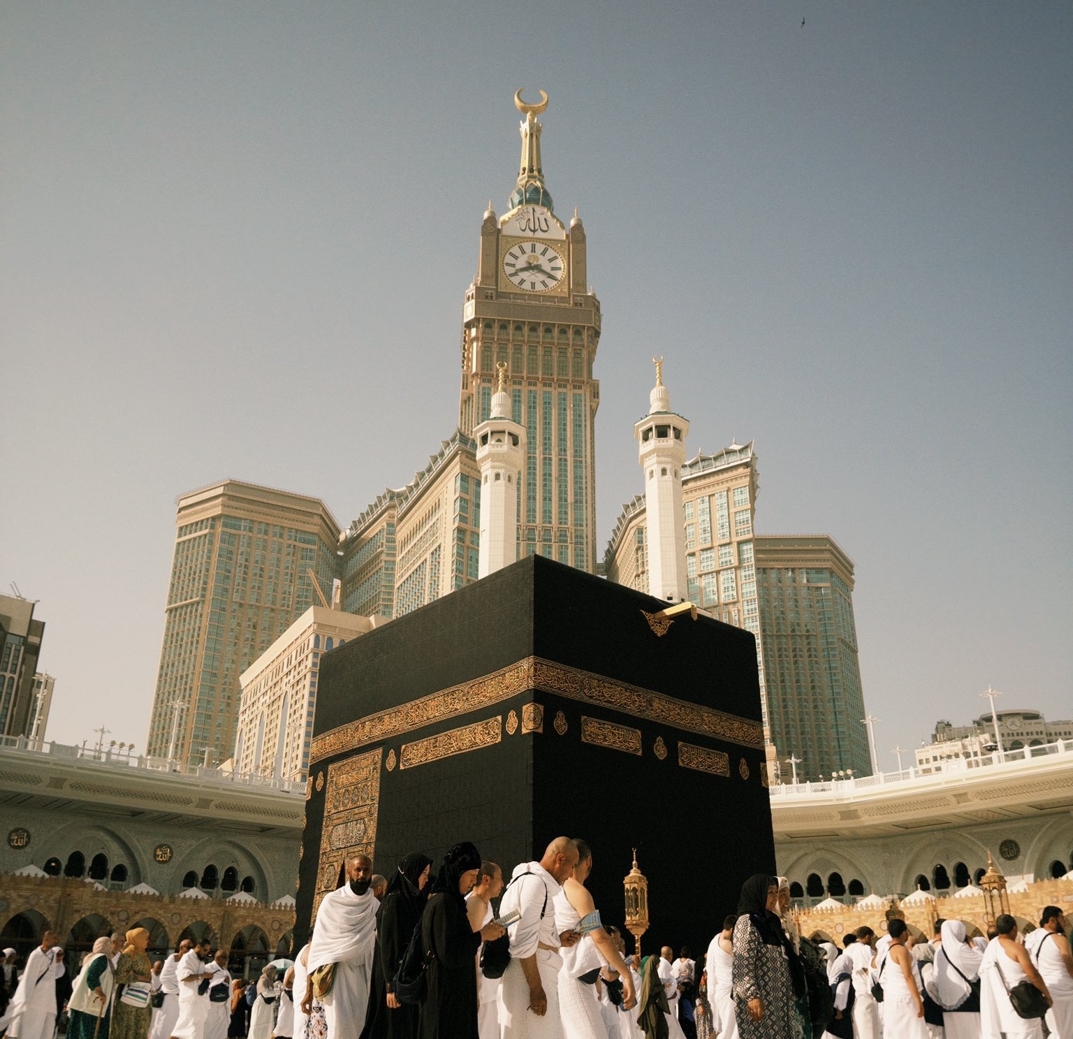 Group organiser reviewing an Umrah rooming list with the Clock Tower in view